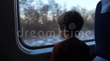 小男孩坐火车在窗外看。 旅行概念。 提前放假。 学龄前儿童